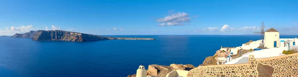 Molino de viento tradicional y apartamentos en el pueblo de Oia, Santorini es — Foto de Stock