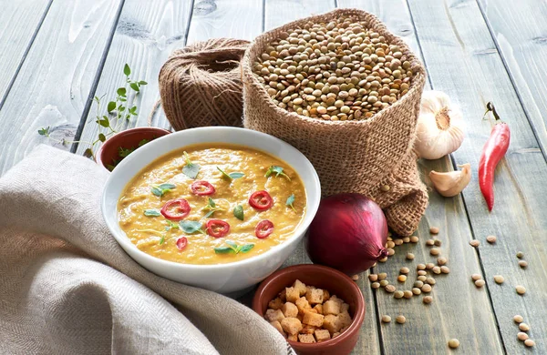Spicy lentil soup with chili, garlic and onion on wooden table — Stock Image Spicy lentil soup with chili, garlic and onion on wooden table Stock Image