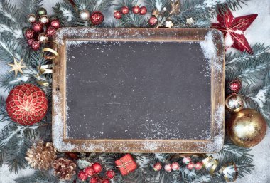 Karda Noel süsleri olan karatahta