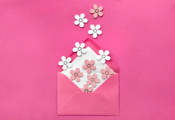 Primavera plana sobre papel rosa con flores decorativas y sobre — Foto de Stock