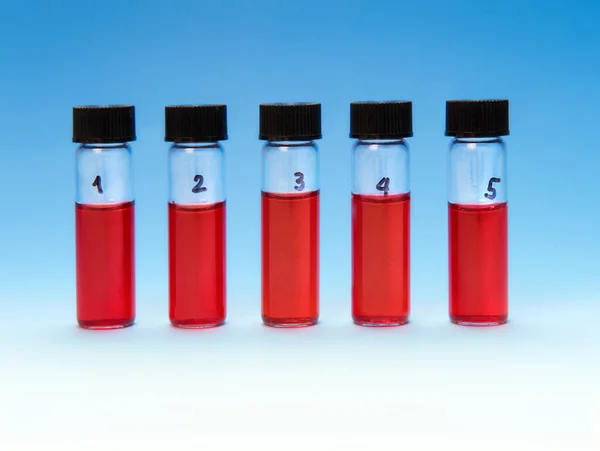Piros folyadékminták átlátszó műanyag tálcán kék színnel — Stock Fotó