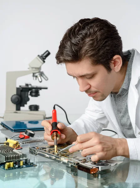 Ung energisk manlig tech eller ingenjör reparerar elektronik — Stockfoto