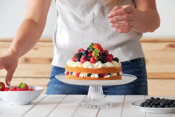 Pastry chef decorates the cake wild berries — Stock Photo, Image