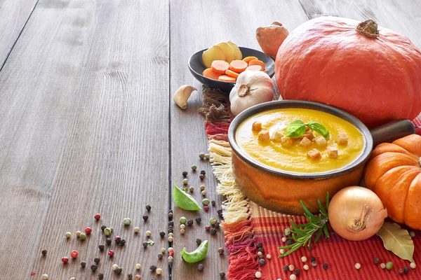 Pumpkin, carrot and ginger creme soup in ceramic pan — Stockfoto