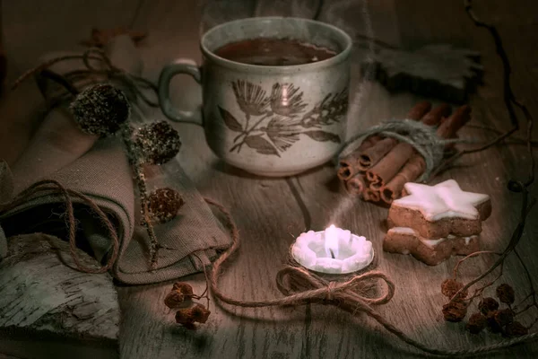 Steaming mug of tea with winter decorations — Stock Photo, Image