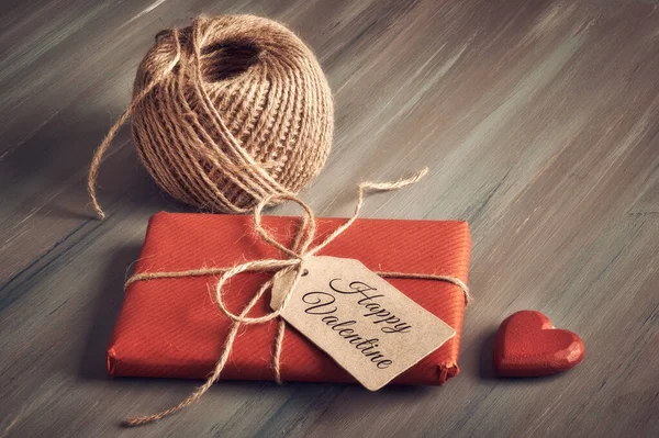 Wrapped gift tied up with cord, cardboard tag with text "Happy V — Stockfoto