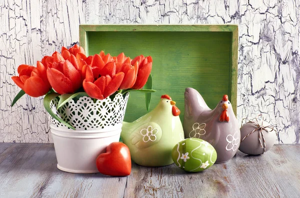 Composición de Pascua con tulipanes rojos; gallinas de cerámica y huevos de Pascua — Foto de Stock