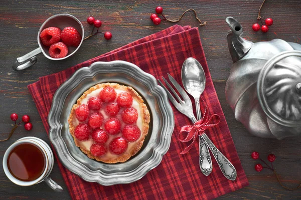Tasty raspberry tart on a vintaege metal plate with tea pot and — Stock Photo, Image