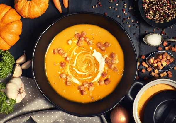 Pumpkin creme soup served with croutons, crushed nuts and cream — Stock Photo, Image