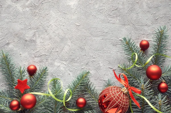 พื้นหลังคริสต์มาสสีเขียวและสีแดงที่มีกิ่งไม้ไพร์ตกแต่ง — ภาพถ่ายสต็อก
