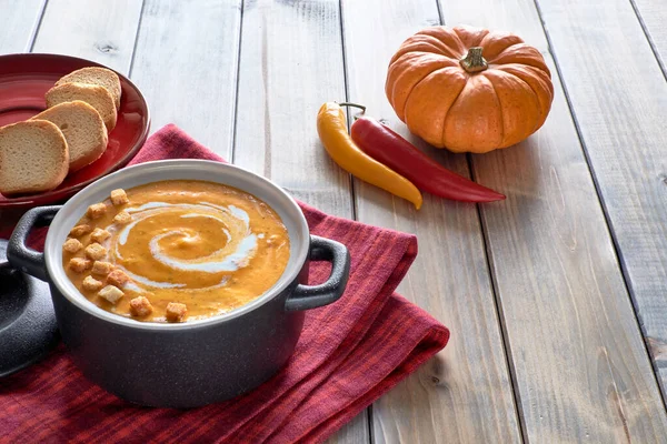 Spicy pumpkin creme soup with carrot and chili pepper — Stock Photo, Image
