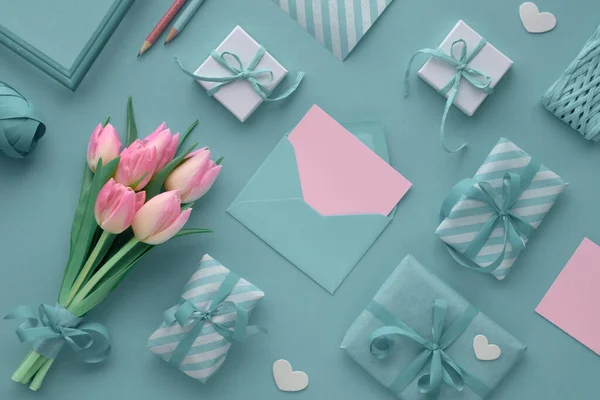 Blauwe achtergrond met roze tulpen, gestreept inpakpapier en wrap — Stockfoto