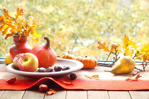 Nature morte d'automne avec citrouilles, fruits, châtaignes et feuilles sèches — Photo