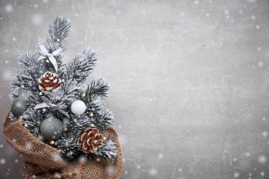 Kırmızı takılarla süslenmiş çuval bezli küçük Noel ağacı.