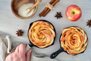 Homemade puff pastry with rose shaped apple slices baked in iron clipart
