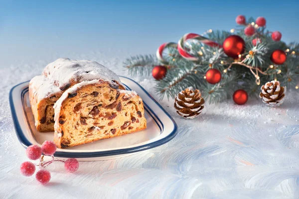 Christmas stollen on white-blue festive background with fir twig — Stock Photo, Image