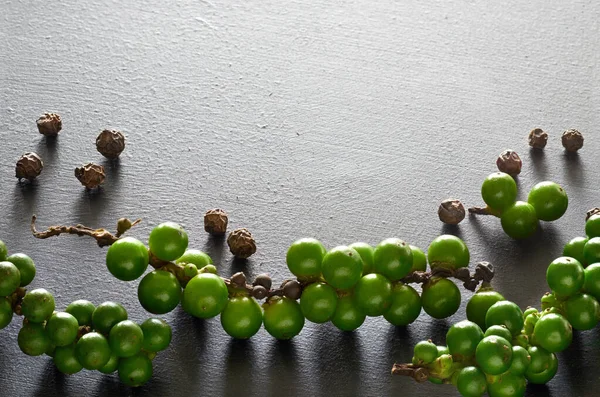 Primer plano en resh granos de pimienta verde en piedra de pizarra gris, espacio — Foto de Stock