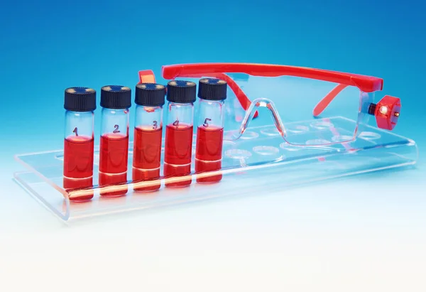 Biológiai vagy orvosi minták és biztonsági szemüveg kék alapon — Stock Fotó