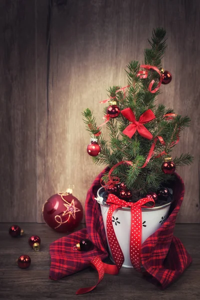 Árvore de Natal decorada e bugigangas vermelhas em fundo de madeira — Fotografia de Stock