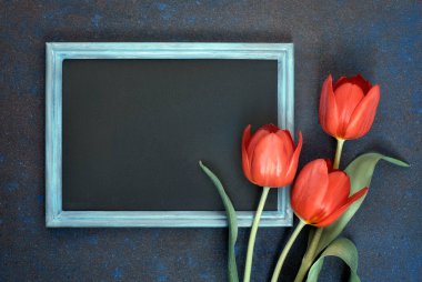 Soyut karanlık arka plan üzerinde siyah tahta ve kırmızı lale demet, test için alan. Düz yatıyordu, tonlu görüntü.