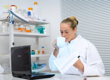 bilim adamı kahve içer ve laboratuar gazetede okur