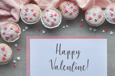 Pembe ve beyaz fondan buzlanma kalpleri ile şeker serpilir muffins