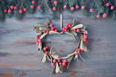 Heart-shaped mistletoe Christmas wreath and festive garland made