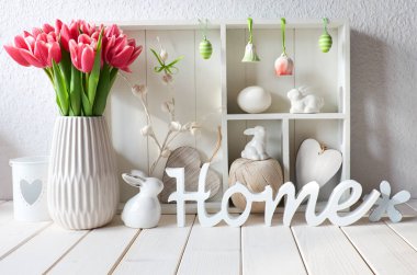 Bahar dönemi arka planında bahar süslemeleri. Farklı nesnelerin ve pembe lalelerin olduğu dolabı göster. Tahtadan yapılmış 