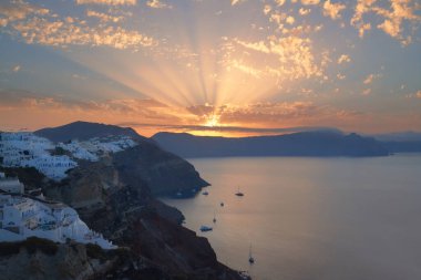 Oia köyü, Santorini 'deki ünlü volkanik kalderanın üzerinde gün doğumu.