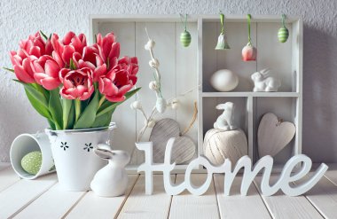 Bahar dönemi arka planında bahar süslemeleri. Farklı nesnelerin ve pembe lalelerin olduğu dolabı göster. Tahtadan yapılmış 