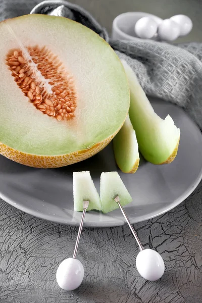 Melona de melón cortada en rodajas sobre plato gris — Foto de Stock