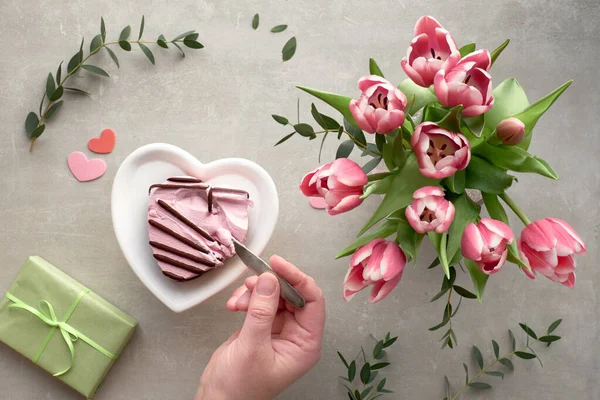 Female hand dipping a spoon in pink heart ice cream and pink tul — 스톡 사진