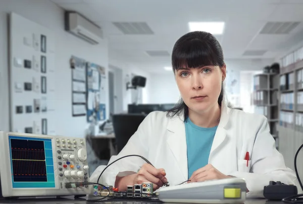 Young female tech or engineer repairs electronic equipment