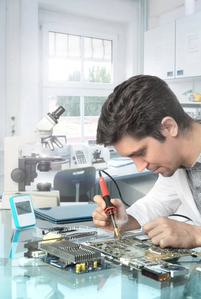 Молодий енергійний чоловічий технік або інженер ремонтує електронне обладнання — стокове фото