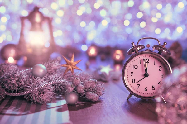 Old alarm clock showing five to midnight and glittering decorati — Stock Photo, Image