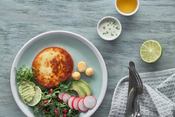 Gebakken ronde plak kaas met groene rucolasalade met avocado — Stockfoto
