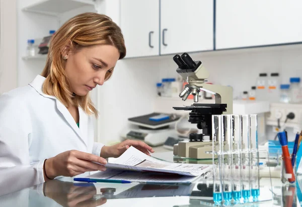 Une jeune scientifique européenne vérifie son journal de laboratoire — Photo