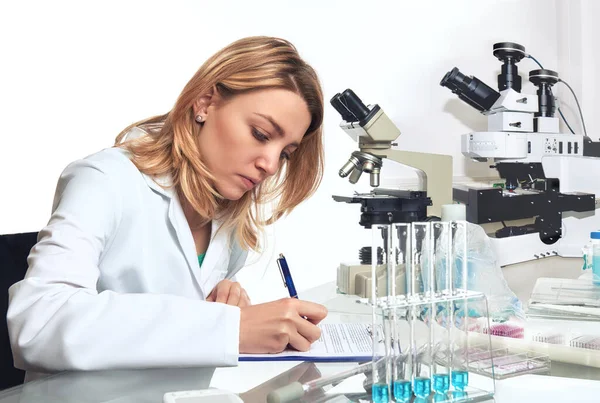 Jovem cientista ou técnica escreve relatório de progresso — Fotografia de Stock