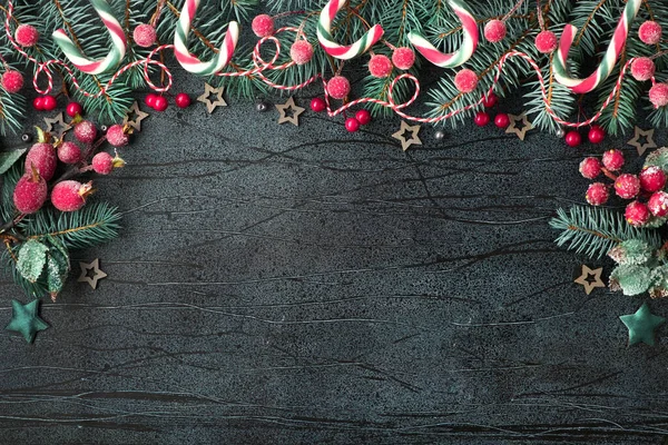 Marco de Navidad con ramitas de abeto, bayas rojas y bastones de caramelo en d — Foto de Stock