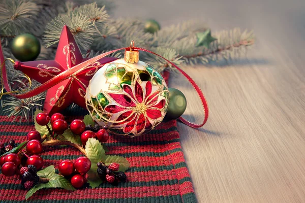 Jularrangemang i rött och grönt på träbord, text spa — Stockfoto