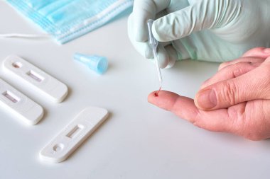 İgm ve IgG 'nin Corona virüsü SARS-CoV-2' yi geliştirerek Covid-19 hastalığına neden olan özel antikorların tespiti için hızlı COVID-19 testi. Sıhhiyeci ya da doktor hasta parmağından kan toplar, ellerine yakın çekim yapar..