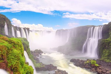 Arjantin 'de Iguazu şelaleleri, Şeytan Ağzı manzaralı. Sis ve alçak bulutlu birçok görkemli ve güçlü su çağlayanı panoramik manzarası. Mavi gökyüzü ve bulutlu Iguazu vadisinin panoramik görüntüsü.