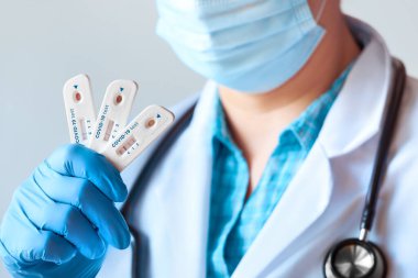 Doktor, Novel Coronavirus, SARS-CoV-2 'ye IgM ve IgG antikorlarının tespiti için yapılan hızlı COVID-19 testini pozitif ve negatif sonuçlarla gösteriyor. Covid-19 'a neden olan yeni Corona virüsüne karşı dokunulmazlık