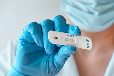Doktor ya da tıp teknisyeni, İgM ve IgG antikorlarının Novel Coronavirus, SARS-CoV-2 'ye gönderildiğini tespit etmek için hızlı bir COVID-19 testi gösteriyor. Covid-19 'a karşı bağışıklık, solunum viral pnömonisi.