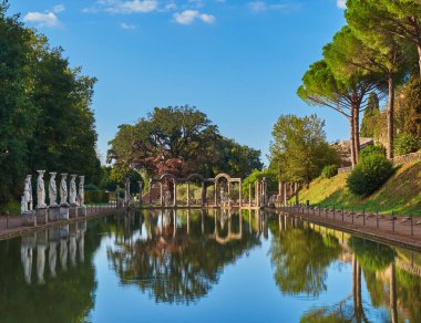 Tivoli, İtalya 27 Eylül 2017: Villa Adriana 'da Yunan heykelleri ve çam ağaçlarıyla çevrili Antik Havuz Canopus.