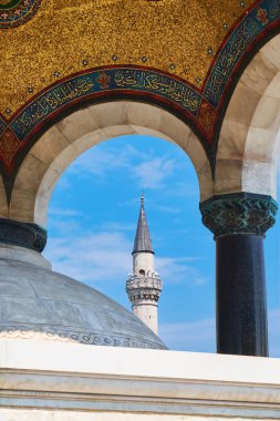 Osmanlı Çeşmesi 'nin bir kemeri tarafından çerçevelenmiş minare