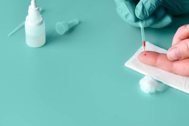 İgm ve IgG antikorları için COVID-19 testi yapın. Yeni Coronavirus SARS-CoV-2, Covid-19. Nitril eldivenli hemşire hasta kanını pipetle topluyor. Gren naneli turkuaz arkaplan, kopyalama alanı.