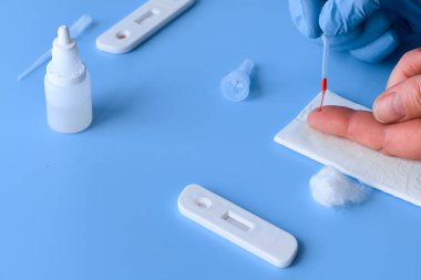 İgm ve IgG antikorları için COVID-19 testi yapın. Yeni Coronavirus SARS-CoV-2, Covid-19. Eldivendeki sıhhiyeciler hasta kanını plastik pipetle topluyor. Canlı mavi veya mor arkaplan.