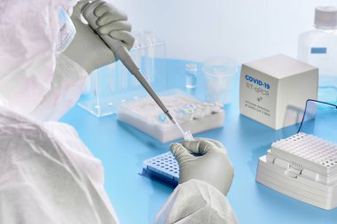 Covid-19 test laboratuvarı. Koruyucu giysi, maske ve gözlük giyen epidemiyoloji uzmanı 2019-nCoV virüsünü tespit etmek için hasta örnekleriyle çalışır. SARS-COV-2 PCR tanı kiti konsepti.