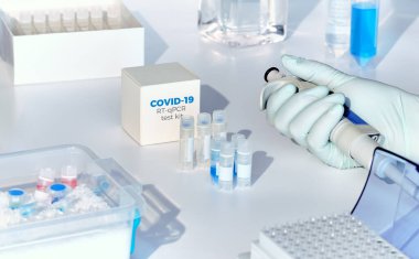 Hızlı bir COVID-19 Coronavirus test kiti. 2019 nCoV PCR tanı kiti. Eldiven içinde pipeti tutuyor. Kit hasta örneklerinde covid19 virüsü tespit etti. Gerçek zamanlı PCR yükseltme sistemi.